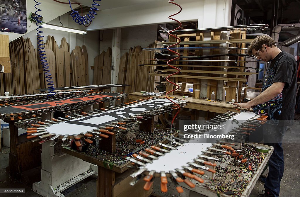 Engineering First Snowboard A worker finishes the edge on a custom-made split snowboard at the ...