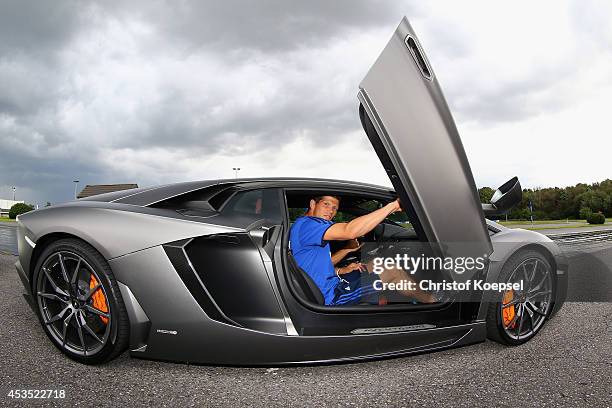 Klaas-Jan Huntelaar of Schalke closes the door of a Lamborghini during a test drive at driving safety centre Rheinberg on August 12, 2014 in...