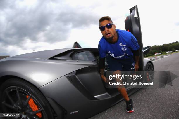 Kevin-Prince Boateng of Schalke gets out of a Lamborghini during a test drive at driving safety centre Rheinberg on August 12, 2014 in Rheinberg,...