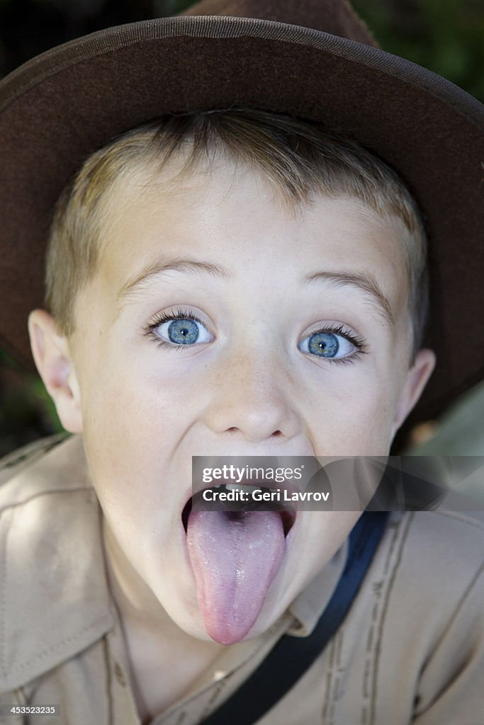 Young boy wearing a hat sticking his tongue out