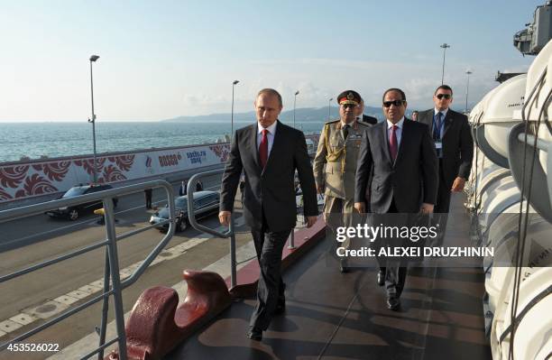 Russian President Vladimir Putin and Egyptian President Abdel Fattah el-Sisi walk along an upper deck of the Black Sea Fleet's guards missile cruiser...