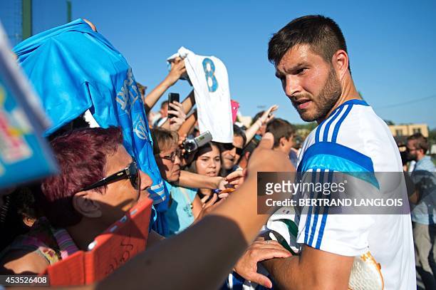 Marseille's French forward Andre-Pierre Gignac signs autographs following a training session on August 12, 2014 at the Robert Louis-Dreyfus training...