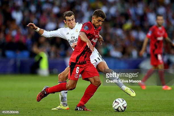 Daniel Carrico of Sevilla is tackled by Gareth Bale of Real Madrid during the UEFA Super Cup between Real Madrid and Sevilla FC at Cardiff City...