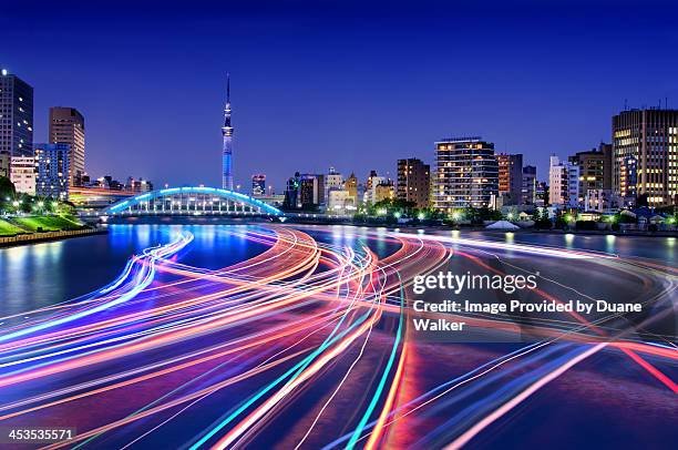 rush hour on tokyo's sumida river - city lights reflected on buildings speed stock pictures, royalty-free photos & images