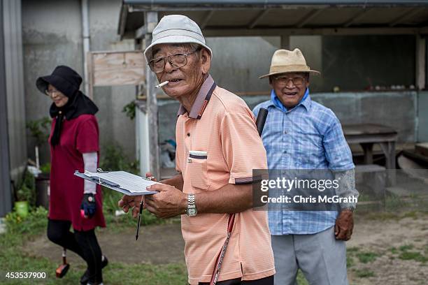 Year old retiree Tashikatsu Suzuki keeps score during a game of ground golf on August 10, 2014 in Omaezaki, Japan. The town of Omaezaki is living in...