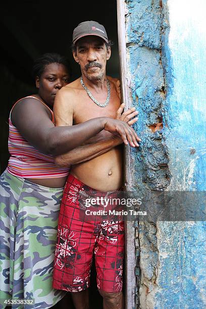 Louis Carlos de Sousa and Tania Gonzalves pose in the doorway of their home in the occupied Complexo da Mare, one of the largest favela complexes in...