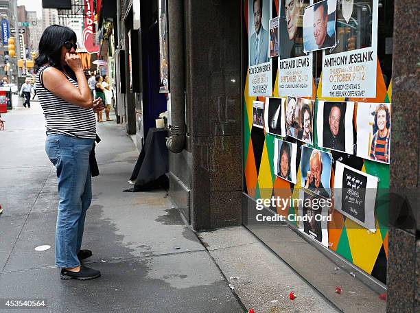 People gather near a makeshift memorial for Robin Williams in front of Carolines on Broadway comedy club on August 12, 2014 in New York City.