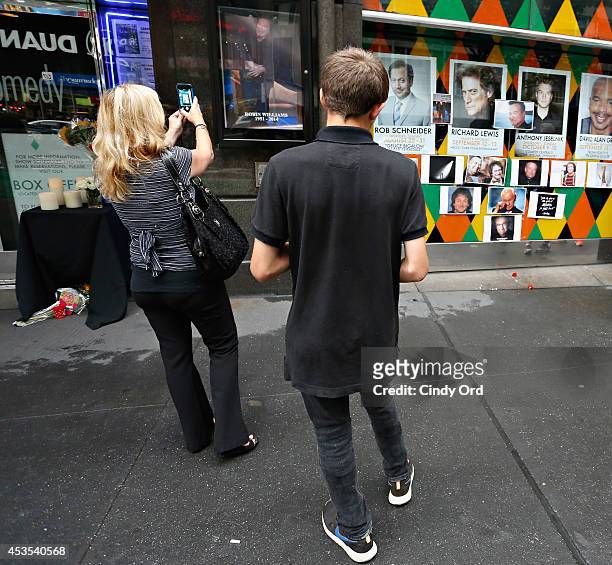 People gather near a makeshift memorial for Robin Williams in front of Carolines on Broadway comedy club on August 12, 2014 in New York City.