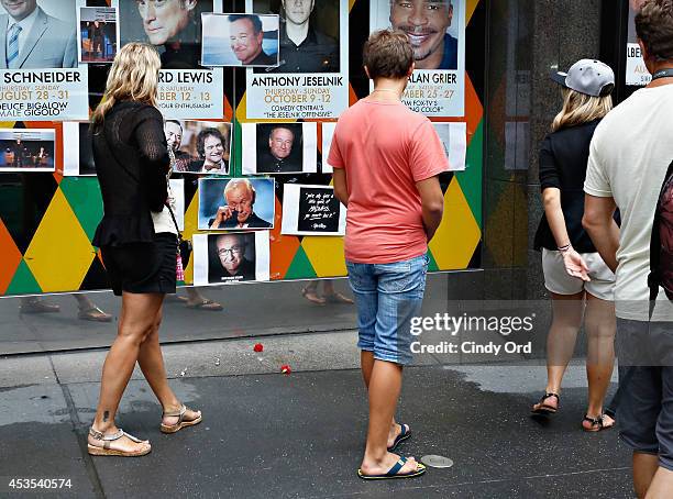 People gather near a makeshift memorial for Robin Williams in front of Carolines on Broadway comedy club on August 12, 2014 in New York City.