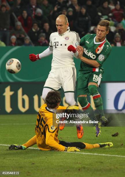 Arjen Robben of Bayern Muenchen fscores his first goal against Matthias Ostrzolek and goalkeeper Marwin Hitz of Augsburg during their DFB Cup round...