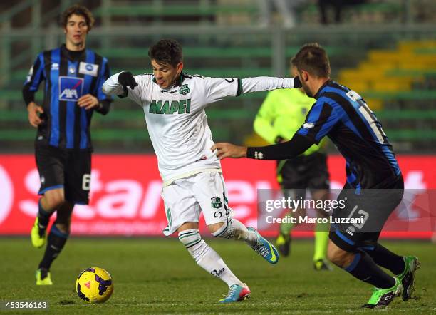 Diego Farias Da Silva of US Sassuolo Calcio competes for the ball with Michele Canini of Atalanta BC during the Tim Cup match between Atalanta BC and...