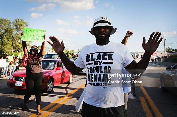 Demonstrators protest the killing of teenager Michael Brown on August 12, 2014 in Ferguson, Missouri. Brown was shot and killed by a police officer...