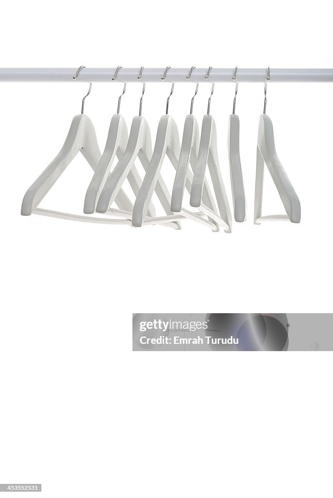 Row of wooden empty hangers on white background