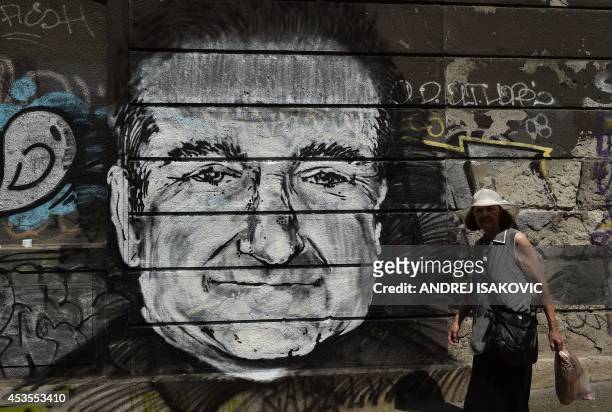 Woman walks past a mural depicting actor Robin Williams in downtown Belgrade on August 13, 2014. Unknown artists drew the Academy Award-winning actor...