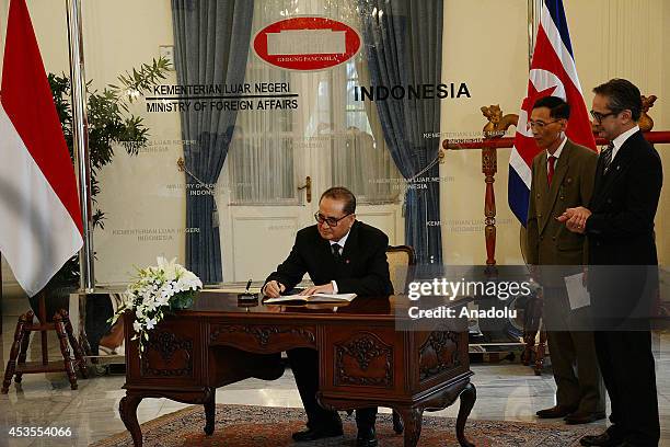 Indonesian Foreign Minister Marty Natalegawa looks on as his North Korean counterpart Ri Su Yong signs guest book before their meeting at the...