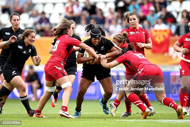 Linda Itunu of New Zealand is tackled by Sioned Harries and Rebecca De Filippo during the IRB Women's Rugby World Cup 5th place match between New...