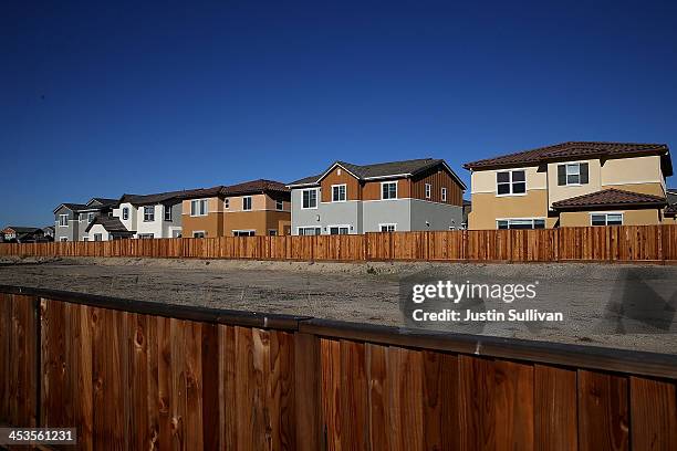 An empty plot of land sits in front of a row of new homes at a housing development on December 4, 2013 in Dublin, California. According to a Commerce...