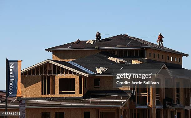 Construction crews work on a new home at a housing development on December 4, 2013 in Dublin, California. According to a Commerce Department report,...