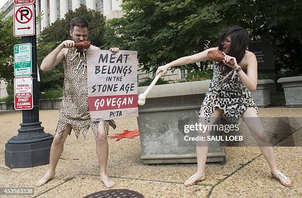 David Salisbury and Alexis Sadoti , dressed as a caveman and cavewoman, participate in a PETA demonstration to promote giving up meat and eating...