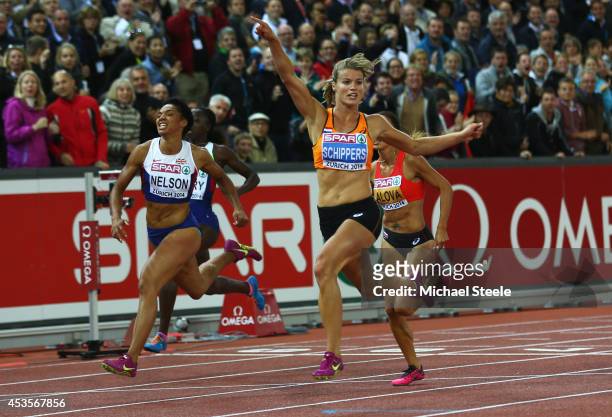 Dafne Schippers of the Netherlands crosses the line to win gold as Ashleigh Nelson of Great Britain and Northern Ireland wins bronze in the Women's...