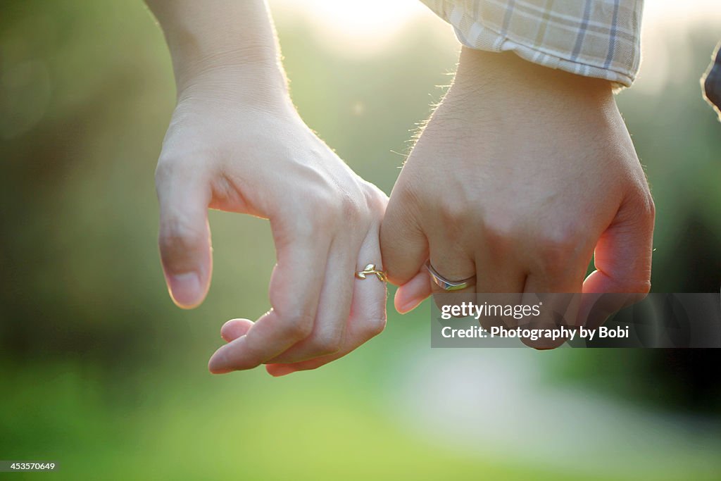 Young couple wearing rings hand in hand