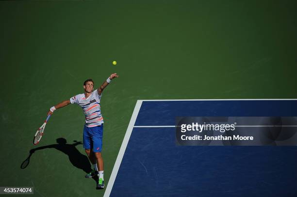 Vasek Pospisil of Canada serves against Roger Federer of Switzerland during a match on day 5 of the Western & Southern open at Linder Family Tennis...