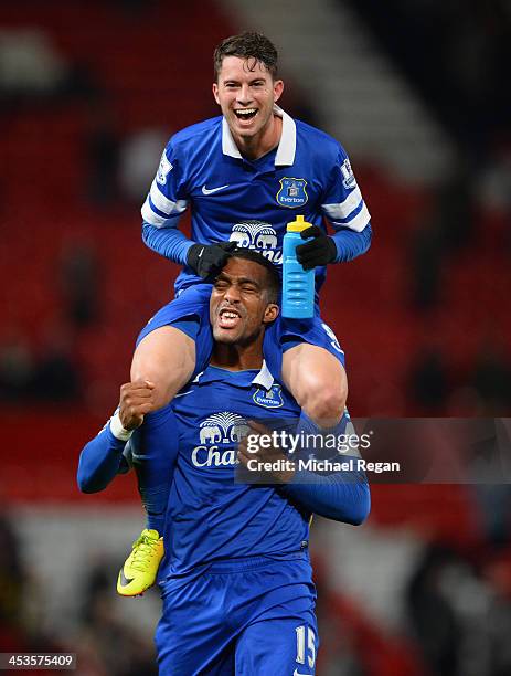 Bryan Oviedo of Everton celebrates with team-mate Sylvain Distin at the end of the Barclays Premier League match between Manchester United and...