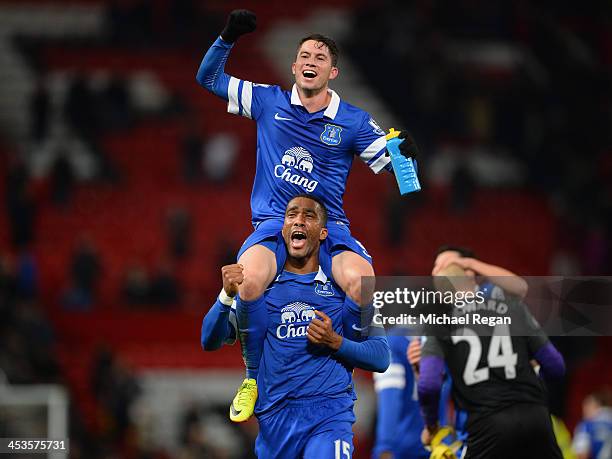 Bryan Oviedo of Everton celebrates with team-mate Sylvain Distin at the end of the Barclays Premier League match between Manchester United and...