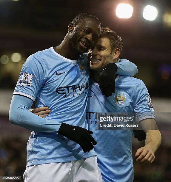 Yaya Toure of Manchester City celebrates with team mate James Milner after scoring his second goal during the Premier League match between West...