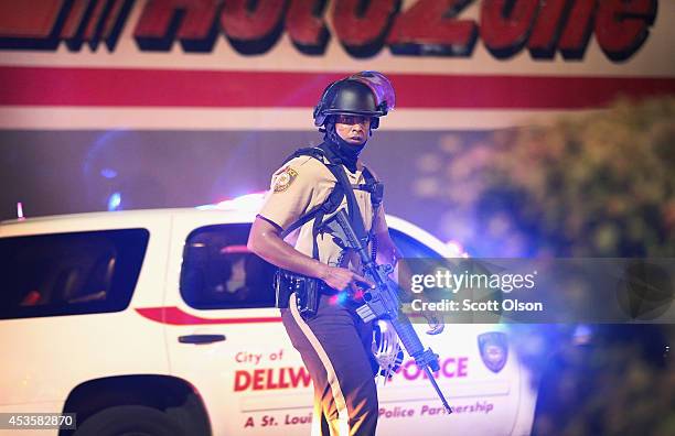 Police officer patrols a business district on August 13, 2014 in Ferguson, Missouri. Ferguson is experiencing its fourth day of unrest after...