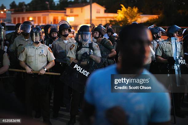 Police stand watch as demonstrators protest the shooting death of teenager Michael Brown on August 13, 2014 in Ferguson, Missouri. Brown was shot and...
