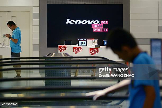 Man visits a Lenovo store in Beijing on August 14, 2014. Lenovo on August 14 posted a 23 percent jump in quarterly net profit, beating market...