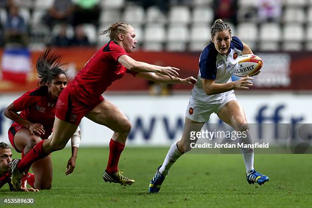 Caroline Ladagnous of France avoids a tackle by Mandy Marchak of Canada during the IRB Women's Rugby World Cup semi-final match between France and...