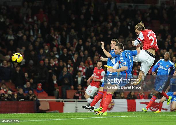 Nicolas Bendtner scores Arsenal's 1st goal past under pressure from James Chester and Alex Bruce of Hull City during the Premier League match between...