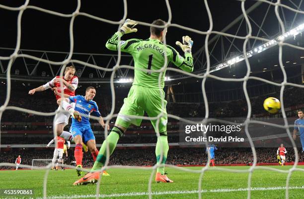 Nicolas Bendtner scores Arsenal's 1st goal past Allan McGregor and under pressure from James Chester of Hull City during the Premier League match...