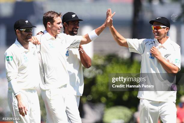 Tim Southee of New Zealand celebrates the wicket of Narsingh Deonarine of the West Indies with Aaron Redmond, Ish Sodhi and Trent Boult during day...