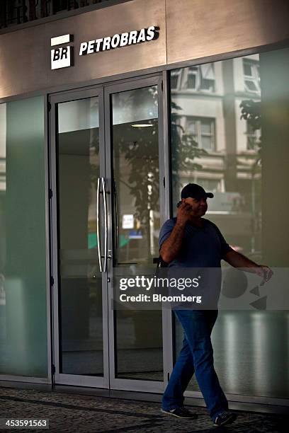 Man walks past Petroleo Brasileiro SA signage in Rio de Janeiro, Brazil, on Wednesday, Dec. 4, 2013. Petroleo Brasileiro SA's failure to disclose the...