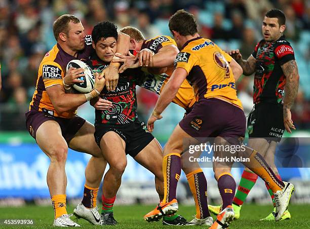 Issac Luke of the Rabbitohs is tackled during the round 23 NRL match between the South Sydney Rabbitohs and the Brisbane Broncos at ANZ Stadium on...