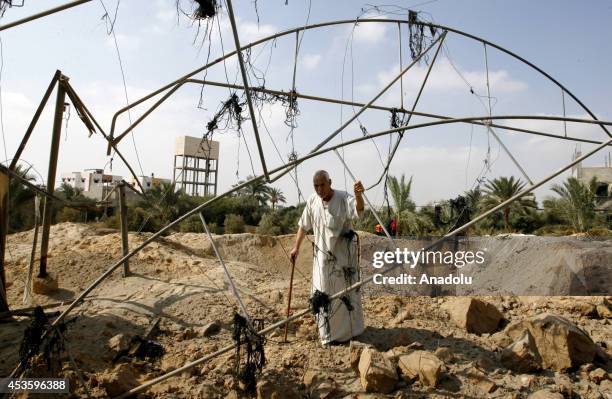 Palestinian man inspects the site of an Israeli strike, ahead of the announcement of a five-day temporary ceasefire in Khan Younis town of Gaza, on...