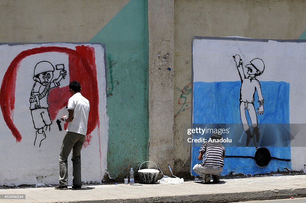 Graffiti artists draw the pictures of killed 14 Yemeni soldiers on the walls of Sanaa