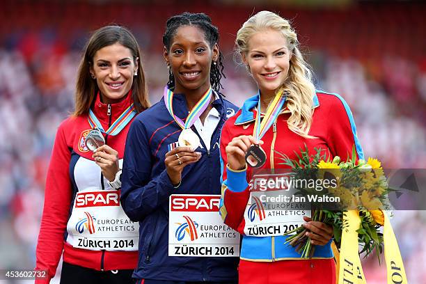 Silver medalist Ivana Spanovic of Serbia, gold medalist Eloyse Lesueur of France and bronze medalist Darya Klishina of Russia stand on the podium...