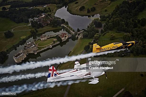 In this handout image provided by Red Bull, Nigel Lamb and Paul Bonhomme of Great Britain fly in formation with Matthias Dolderer of Germany prior to...