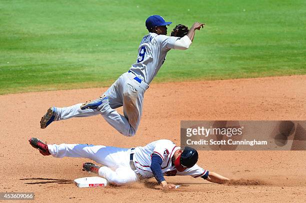 Dee Gordon of the Los Angeles Dodgers turns a seventh double play against Andrelton Simmons of the Atlanta Braves at Turner Field on August 14, 2014...