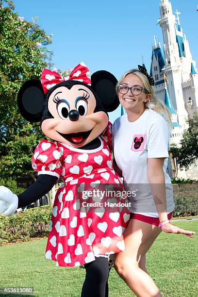 In this handout photo provided by Disney Parks, Actress and country music artist Jamie Lynn Spears poses with Minnie Mouse in front of Cinderella...