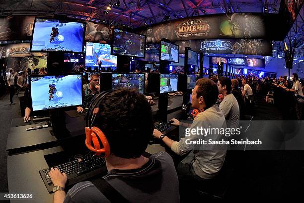 Visitors try out the massively multiplayer online role-playing game 'World Of Warcraft' at the Blizzard Entertainment stand at the 2014 Gamescom...