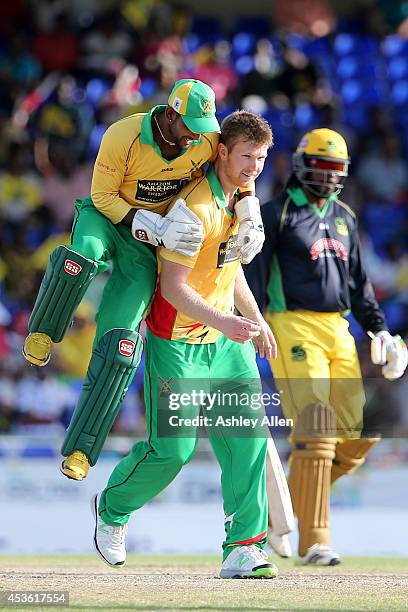 Denesh Ramdin celebrates with team mate Jimmy Neesham as he gets the wicket of Chris Gayle during a Semifinal match between Jamaica Tallawahs and...