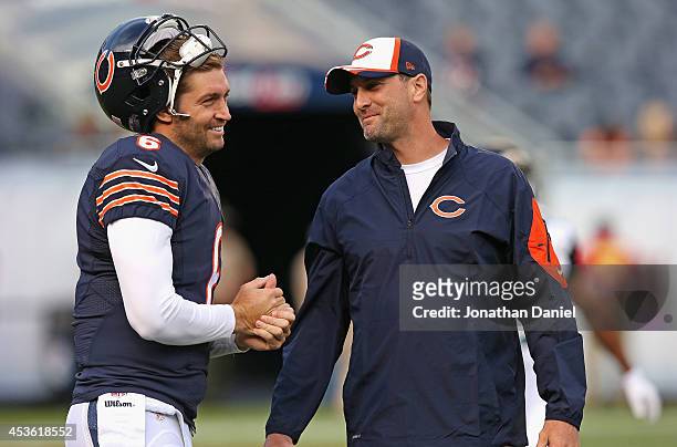 Jay Cutler of the Chicago Bears talks with wide receivers coach Mike Groh during warmups prior to a preseason game against the Jacksonville Jaguars...