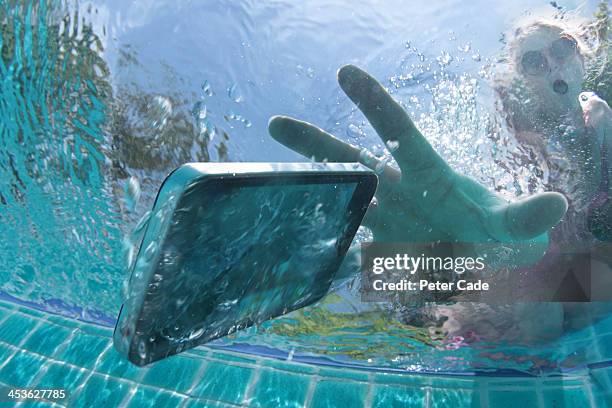 woman dropping phone into swimming pool - chest or bust foto e immagini stock