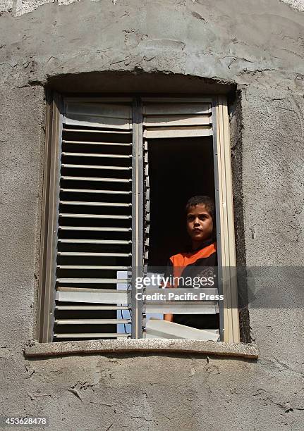 Palestinian girl looks outside from their damage window from an Israeli air strike in some parts of Khan Younis in the Southern of Gaza City....