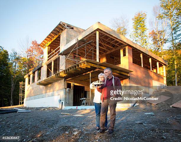 senior couple discussing the construction of new home - new build house stock pictures, royalty-free photos & images